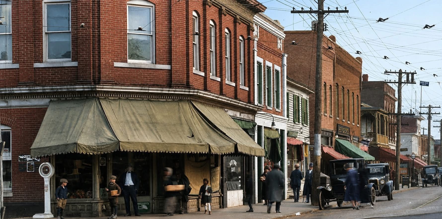 Historic Queen Street in Downtown Hampton, Virginia, showing early 20th-century brick storefronts, pedestrians, and automobiles along one of Hampton Roads’ oldest commercial corridors.